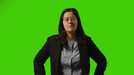 Studioporträt-Einer-Geschäftsfrau-Mit-Brille,-Die-Vor-Grünem-Hintergrund-Steht